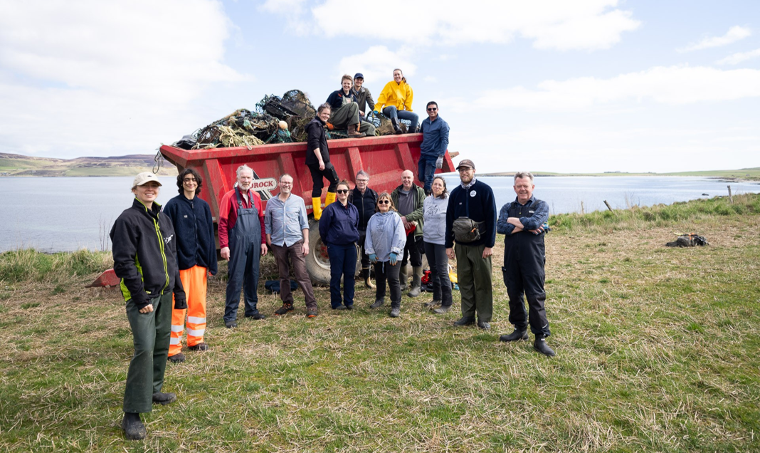 Photo 1: The beach cleaning group at Evie beach, mainland Orkney in front (and on top) of some of the litter collected. Credit: Maurizio Milesi.  
